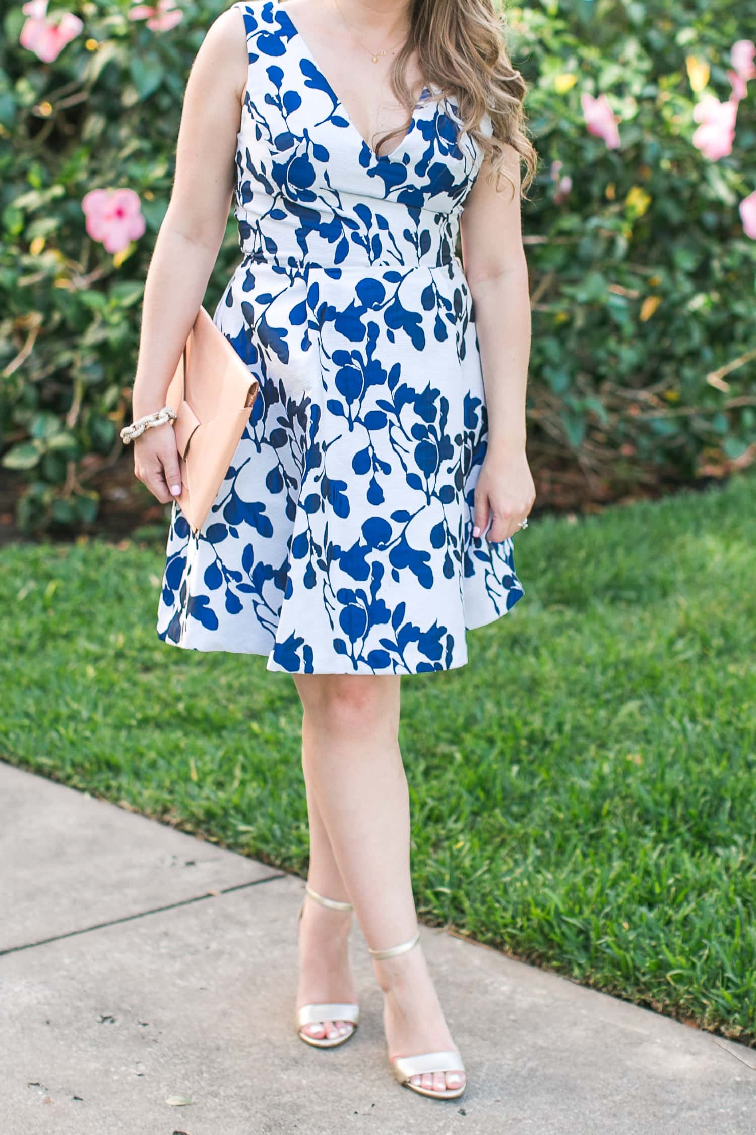 The perfect floral fit and flare dress | what to wear to a wedding | cute maternity outfit idea | dressy outfit idea by Orlando Florida fashion blogger Ashley Brooke Nicholas | preppy fashion, preppy style, beautiful dresses | Betsey Johnson floral dress, Sam Edelman metallic gold heeled sandals Yaro, Banana Republic nude bow clutch