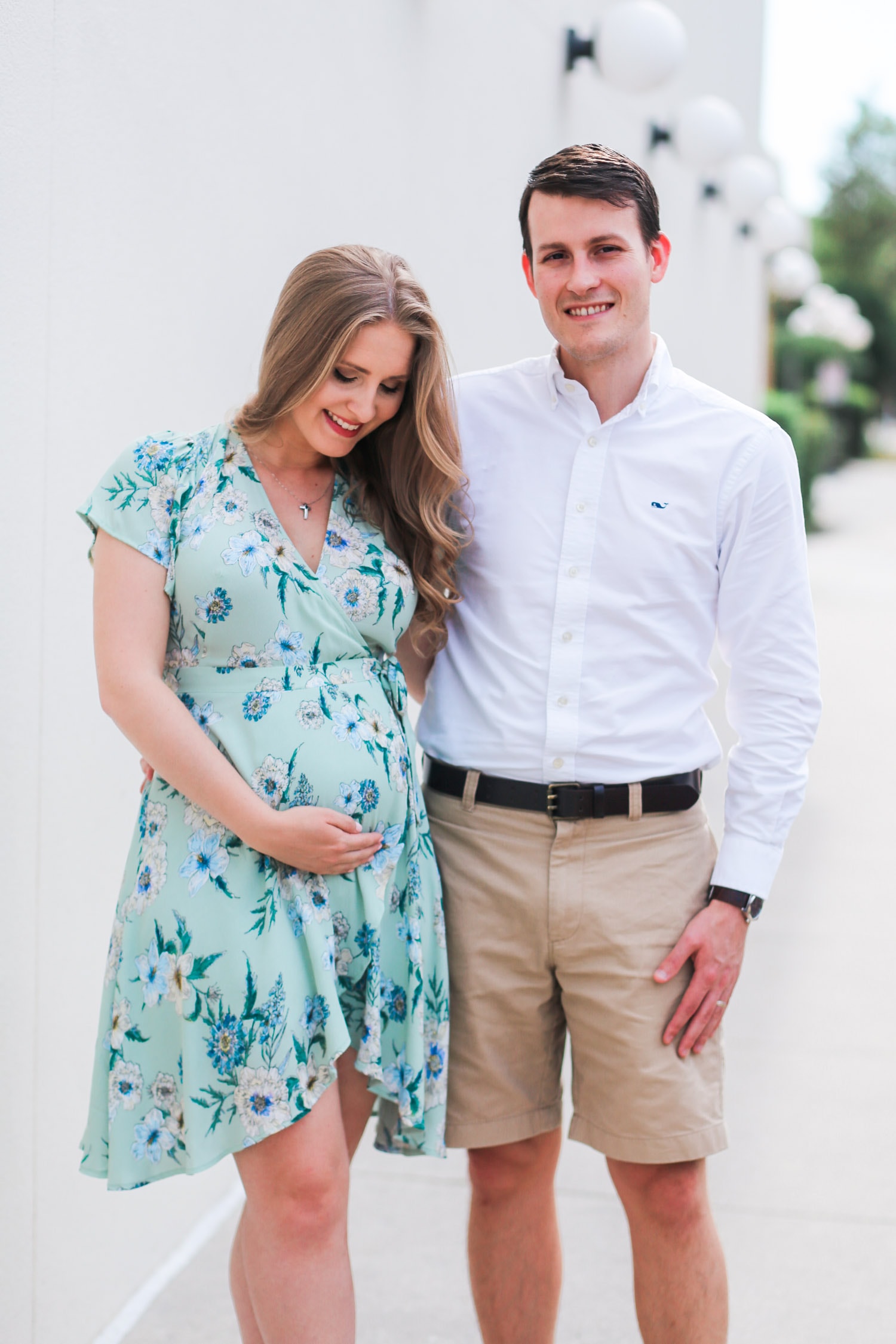 Cute pregnancy announcement photo idea | Rose gold Oh Baby balloons | ASTR pale green floral wrap dress | Flattering maternity dress | Florida beauty and fashion blogger Ashley Brooke Nicholas
